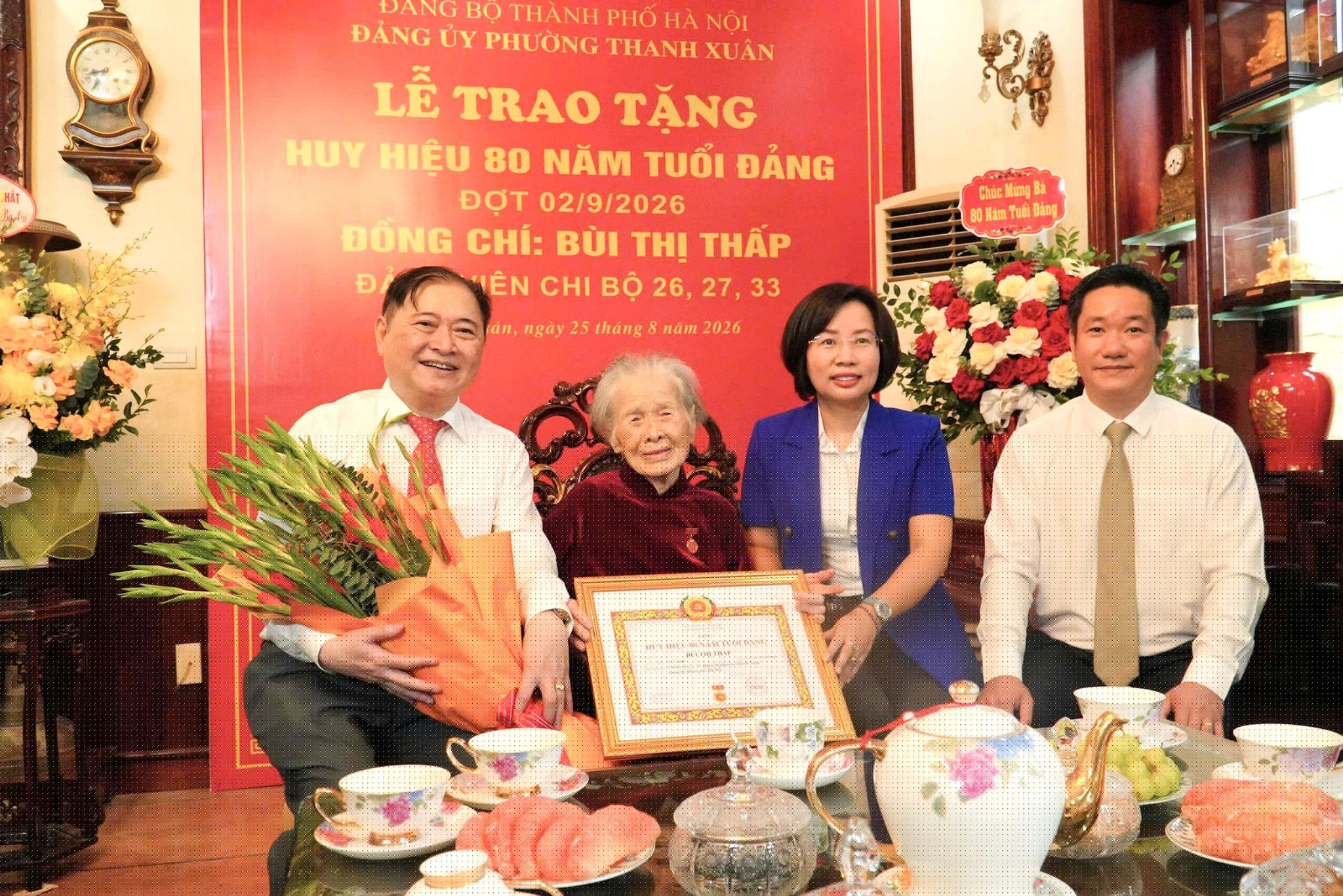Đồng chí Bùi Huyền Mai, Ủy viên Ban Thường vụ Thành ủy, Chủ tịch Ủy ban MTTQ Việt Nam thành phố Hà Nội trao Huy hiệu 80 năm tuổi Đảng tặng đảng viên lão thành Bùi Thị Thấp. Cùng dự có đồng chí Nguyễn Huy Cường, Bí thư Đảng ủy, Chủ tịch HĐND phường Thanh Xuân (ngoài cùng bên phải). Ảnh: Tùng Lâm