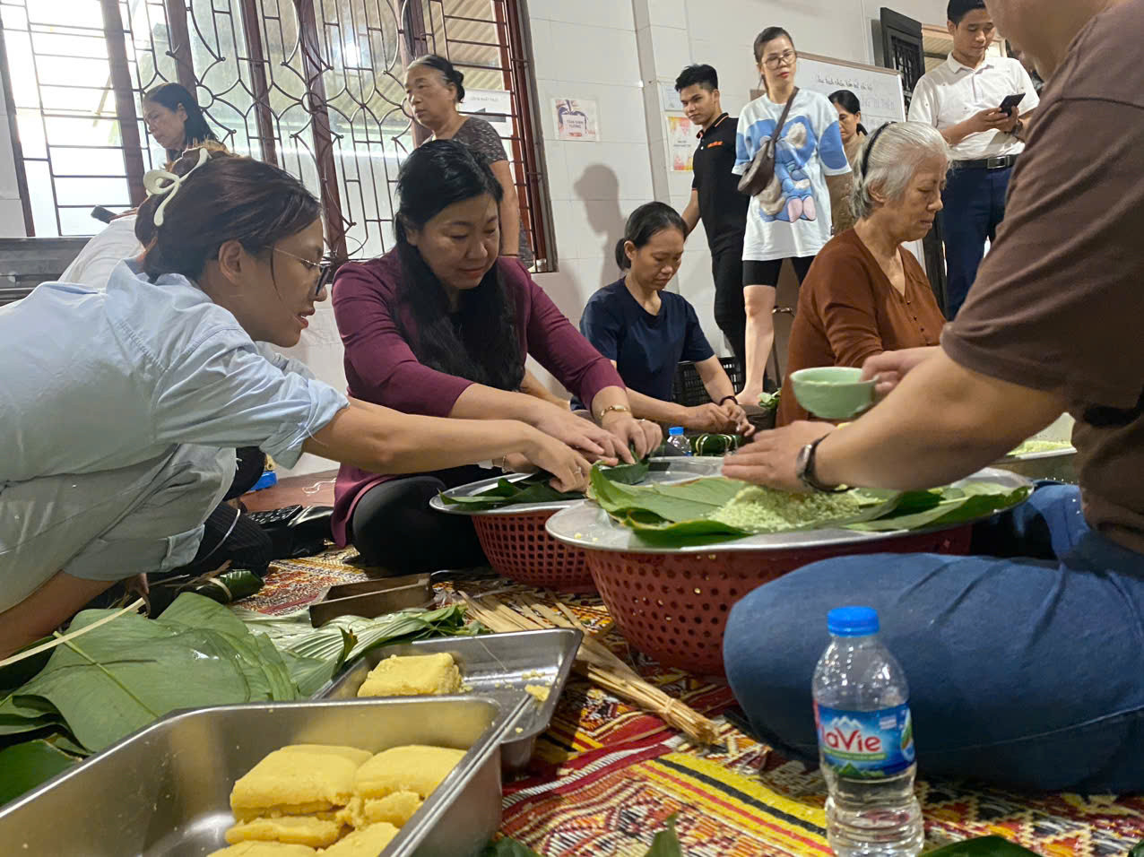 Chủ tịch Ủy ban MTTQ Việt Nam thành phố Nguyễn Lan Hương gói bánh chưng cùng các phật tử chùa Đình Quán, phường Phúc Diễn (quận Bắc Từ Liêm). Ảnh: Hiền Phương