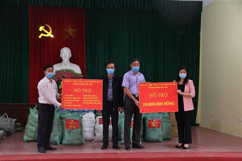 Đại diện lãnh đạo thành phố Hà Nội trao quà hỗ trợ của thành phố đến các hộ dân thôn Đông Cứu